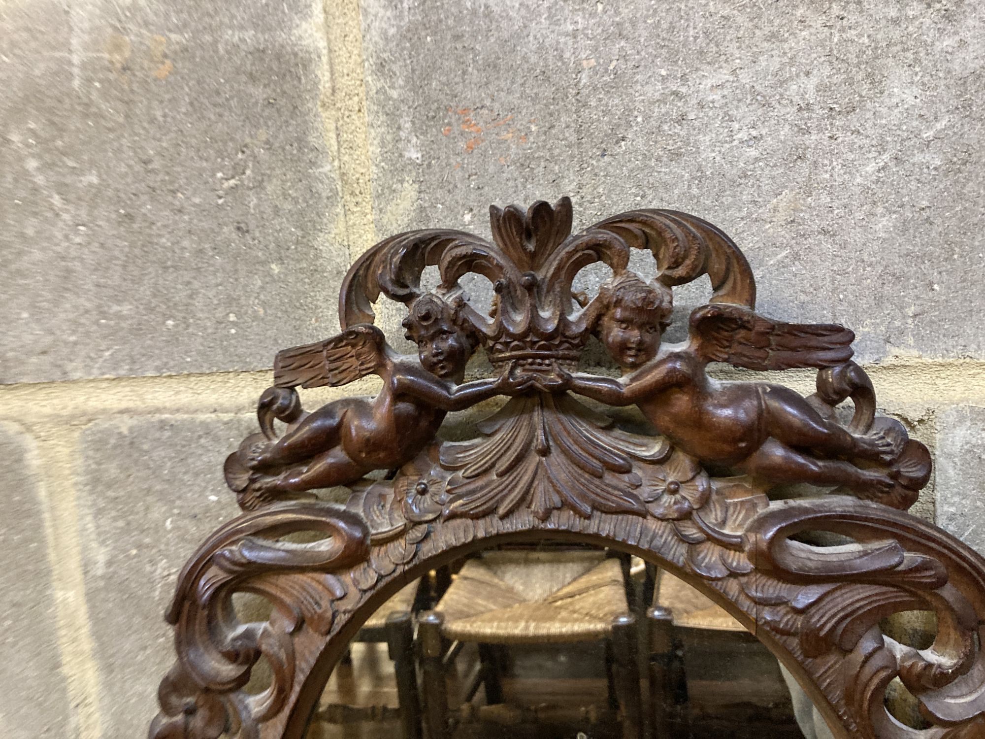 A Carolean style carved walnut oval mirror, width 48cm, height 68cm